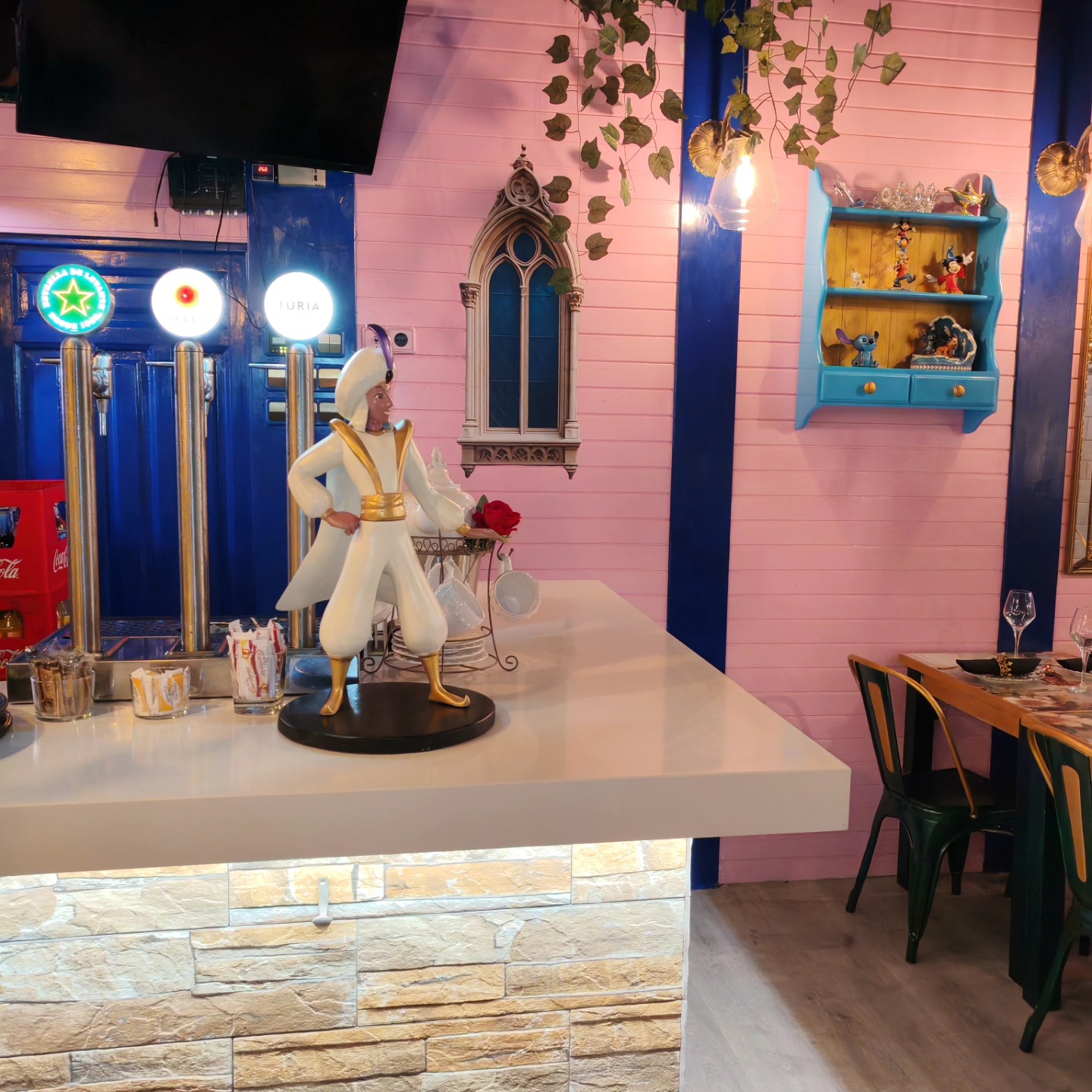 Zona de barra del restaurante El Bosque Encantado en Almería, con decoración colorida, figuras de personajes de cuento y ambiente mágico